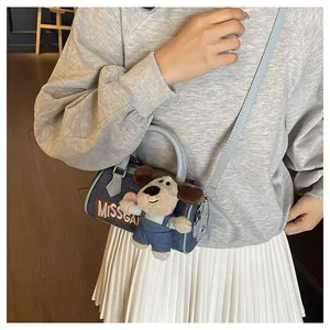 Detail of denim Boston bag with Miss Gai embroidery and cute plush puppy charm