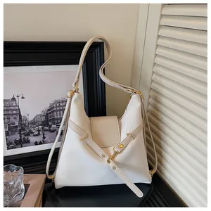 Detail van de roomwitte olie-was lederen tote tas met gouden gespen en reliëflogo