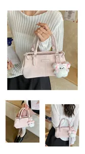 Detail of light pink large bucket bag with fashion metal plate and plush bear charm