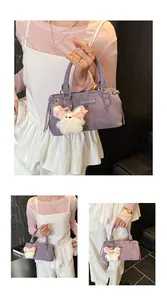 Detail of lavender textured crossbody bag with a white plush rabbit charm accessory
