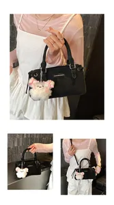 Detail of black canvas bucket bag featuring a fashion logo tag and a cute plush bear charm