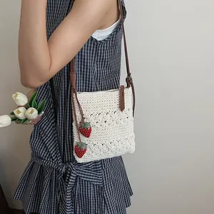 Sac bandoulière en paille tressée avec motifs ajourés et breloques fraises