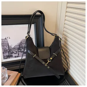 Detail van zwarte waxlederen shopper met metalen haak en matte afwerking textuur