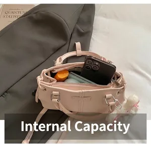 Detail view showing internal capacity of pink leather bag with phone and makeup accessories