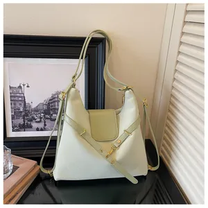 Detailopname van de mintgroene lederen tote tas met gouden hardware en riemdetails