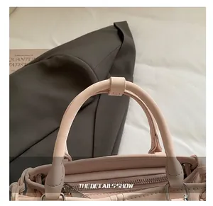 Detailed close-up of light pink leather handle with silver metal zipper and hardware