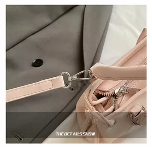 Close-up of high-quality silver metal hook and strap connector on pink leather handbag