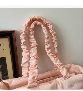 Detailed close-up of pink puffy tote bag showing reinforced pleated handles and zipper
