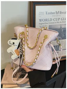 Close-up of pink quilted bucket bag with gold chain strap and horse charm detail