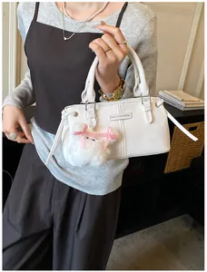 Detail view of cream white PU leather handbag featuring fashion embossed text and dog charm