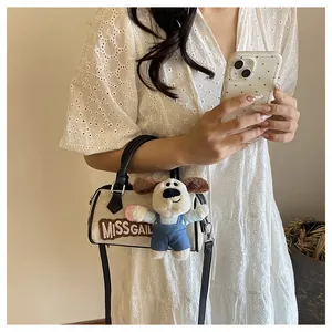Close-up of canvas Boston bag with MISSGAIL embroidery and cute puppy plush charm