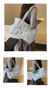 Light blue quilted nylon tote bag featuring a scrunchie shoulder strap and cloud texture