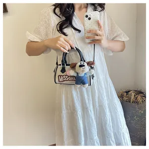 Detail of canvas Boston bag with MISSGAIL lettering and cute plush dog pendant charm