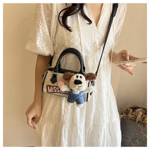 Close-up of beige fabric Boston bag featuring MISSGATE embroidery and puppy plush charm