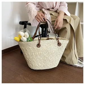 Nahaufnahme der beige handgewebte Tragetasche mit braunen Ledergriffen und feiner Textur