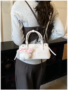 White bucket shoulder bag with plush dog charm shown in a daily lifestyle setting