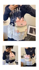 Detail view of woven straw crossbody bag with pink bow accent and chain strap worn by model