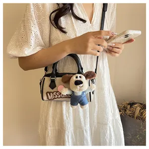 Detail of canvas Boston bag featuring MISS GAIL embroidery and cute puppy plush charm