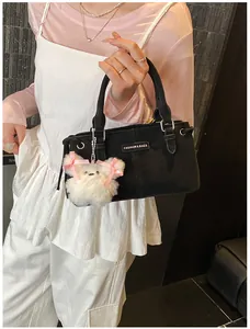 Detail of black canvas bucket bag with plush bear charm and Fashion & Bags leather label