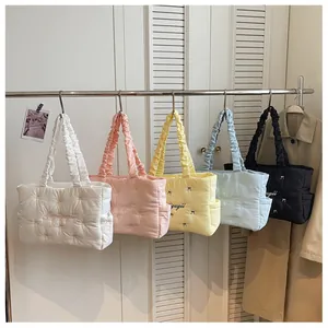 Detail showing colorful quilted nylon tote bags with bow accents and wave stitching pattern