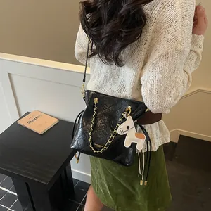 Quilted black leather bucket bag with gold chain and horse charm for spring fashion