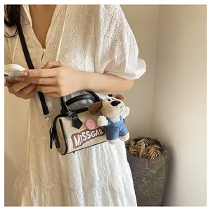 Detail of beige Boston bag with Miss Gail embroidery and cute plush dog pendant charm