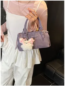 Detail of purple velvet bucket bag with Fashion label and cute white rabbit charm