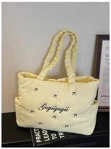 Close-up of quilted nylon tote bag with bow embroidery and ruffled handle design