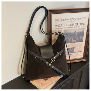 Detail van vintage oliewas lederen tas met gouden gespen en zwarte lederen accenten