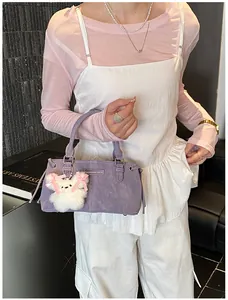 Detail of purple large-capacity bucket bag with plush bear charm and fashion metal plate