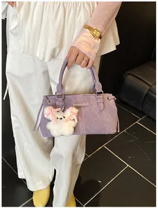 Detail of lavender bucket bag with fashion label and cute white plush bear charm