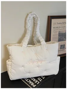 Detail of white quilted nylon tote bag with pink bows and ruched cloud handle
