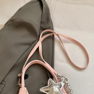 Detail van verstelbare roze lederen schouderband met zilveren ster en metalen gesp