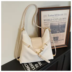 Detail van beige hobo-tas van oliewasleder met gouden gespen en reliëflogo