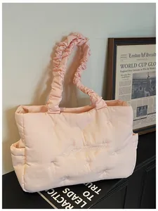 Detail of light pink quilted tote bag with bow embroidery and ruffled scrunchie handle
