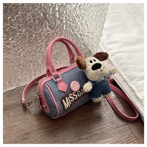 Blue denim Boston bag featuring pink handles and a cute cartoon puppy plush pendant