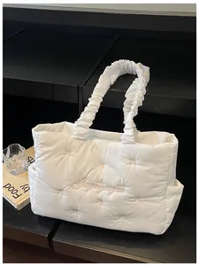 Detailed shot of white quilted nylon tote bag with pink bow embroidery and ruffled handle