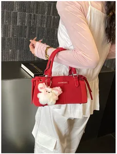 Detail of red suede bucket bag with white bunny charm and Fashion & Bags label