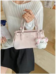 Detail of light pink large capacity bucket bag with fashion plate and plush bear charm
