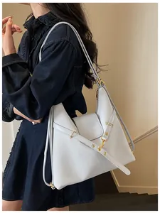 Detail van lichtblauwe hobo-tas van oliewasleer met gouden hardware en mode-reliëf