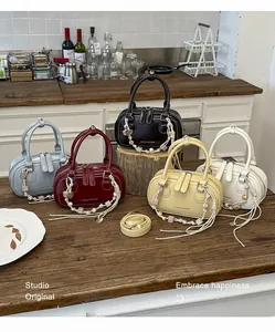 Detailed close-up of five colorful Boston bags with tassels on a wooden counter