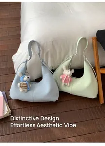 Détail du sac à main souple avec bandoulière tissée et joli pendentif tricoté