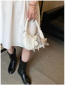 Detail van witte hobo tas met sterrenprint, zilveren sterhanger en metalen koord