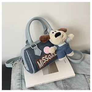 Detail of blue denim Boston bag with dog plush charm and MISSGAIL embroidery