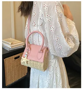 Mini straw woven crossbody bag with pink leather flap and starfish charm on a white dress