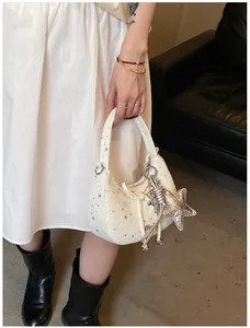 Detail van witte hobo-tas met sterrenprint en een grote zilverkleurige metalen sterhanger