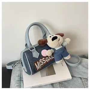 Close-up of light blue denim Boston bag featuring MISS GAIL embroidery and puppy charm