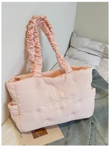 Detail of pink quilted nylon tote with ruffle handle, embroidery, and bow accents