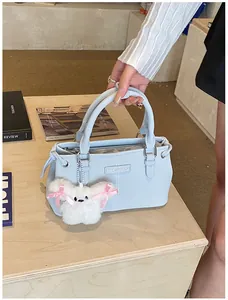 Close-up of a light blue textured bucket bag featuring a cute white plush puppy charm