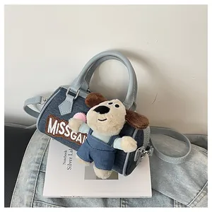 Blue denim Boston bag with leather handles and a cute plush puppy doll charm detail